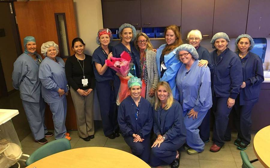 Scripps La Jolla nurse, Cynthia Clarke-Horvath, holds a bouquet and celebrates her CARE award win with co-workers.
