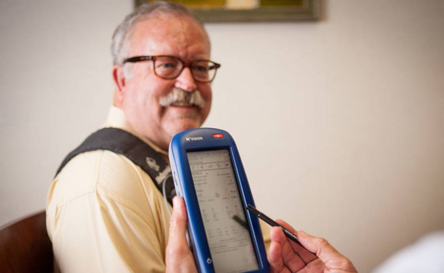 A middle-aged man sits with a medical professional during a DBS programming session for treatment for Parkinson's symptoms.