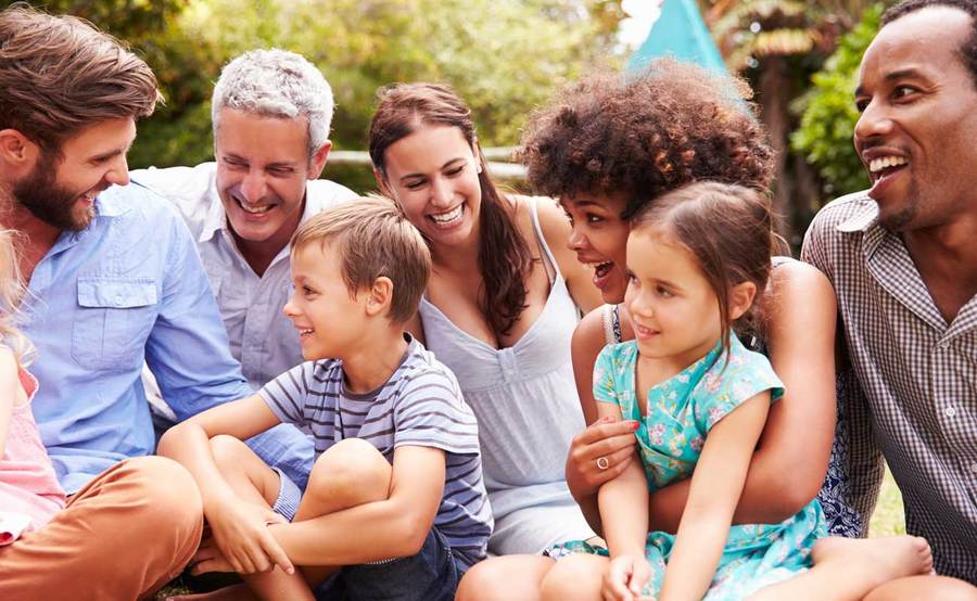 A group of family and friends sits outside, representing a healthy lifestyle. 