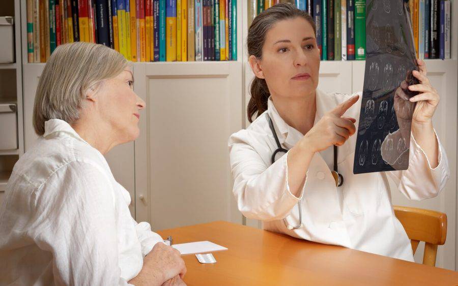 A physician explains the results of a CT scan to her stroke patient.