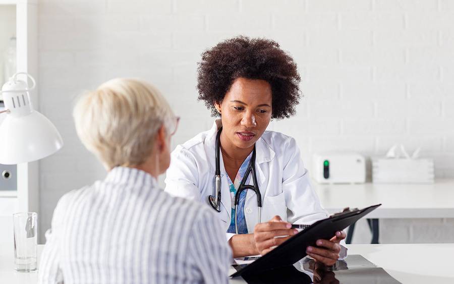 An oncologist discusses care with a cancer patient.