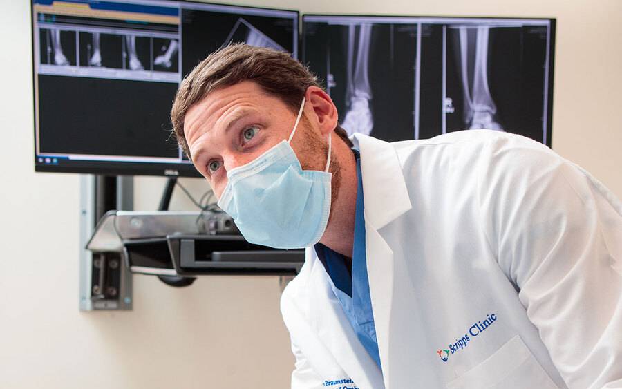 Orthopedics surgeon Jacob Braunstein, MD with x-ray images in the background.