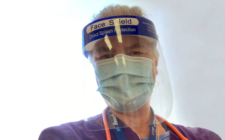 Dr. Noemi Doohan, a Scripps physician and recent cancer patient, smiles at the camera behind a face shield and mask.