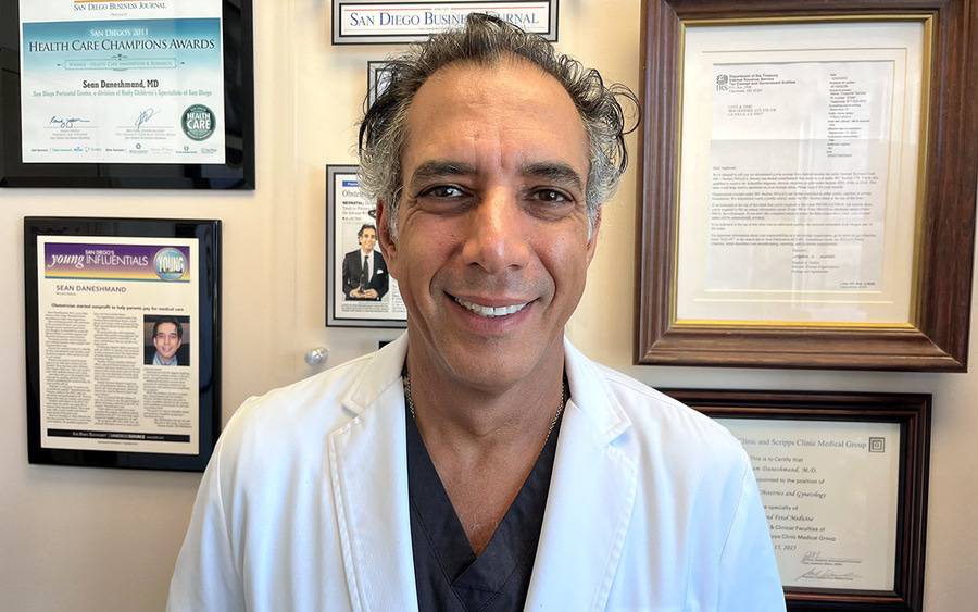 Dr. Sean Daneshmand, in a white lab coat, in his office. 