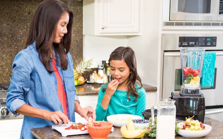 A mom and daughter prepare a healthy meal.
