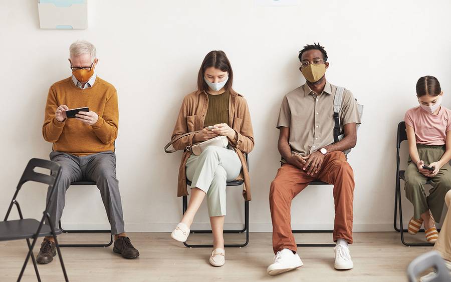 Patients with masks wait in the emergency department.