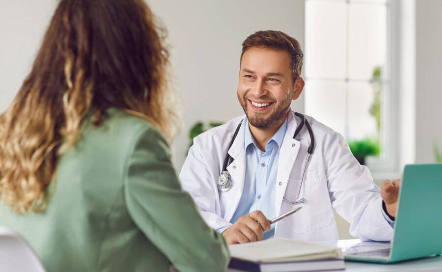 A physician talks with a patient, representing common questions about Scripps Center for Executive Health.