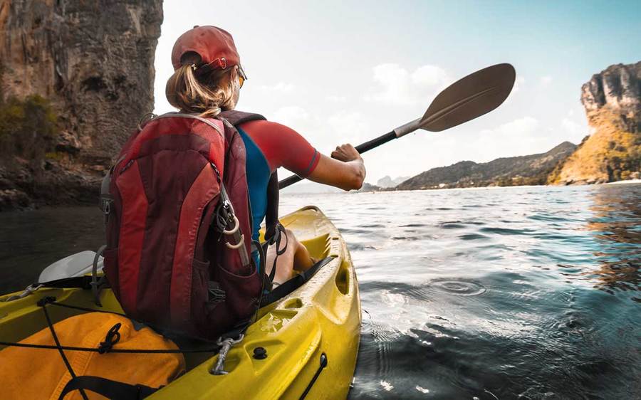 A woman kayaks into coastal caves in San Diego.