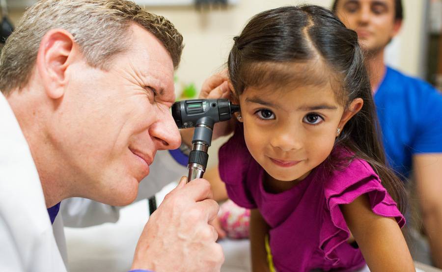 Dr. Mark Shalauta, Family Medicine, Scripps Clinic examines the ear of a young girl during her appointment.