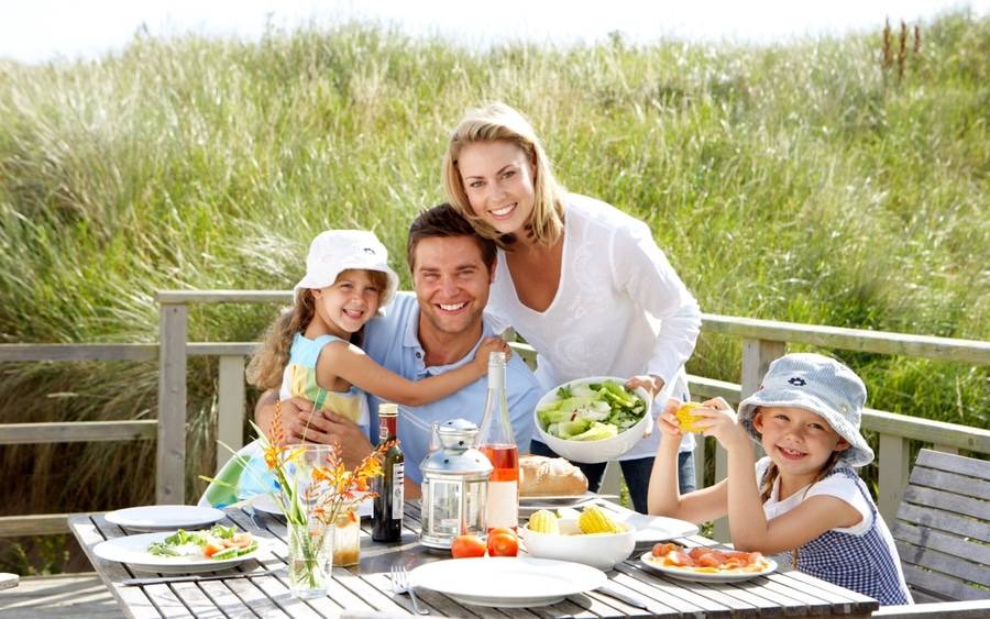 Mom, dad and two chidren eating healthy during vacation
