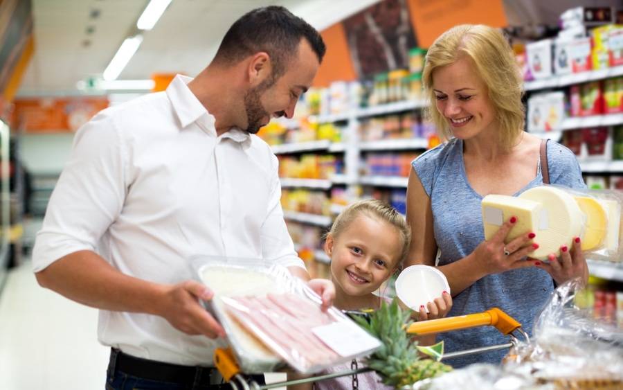 A father, mother and young daughter with celiac disease shop for gluten free foods.