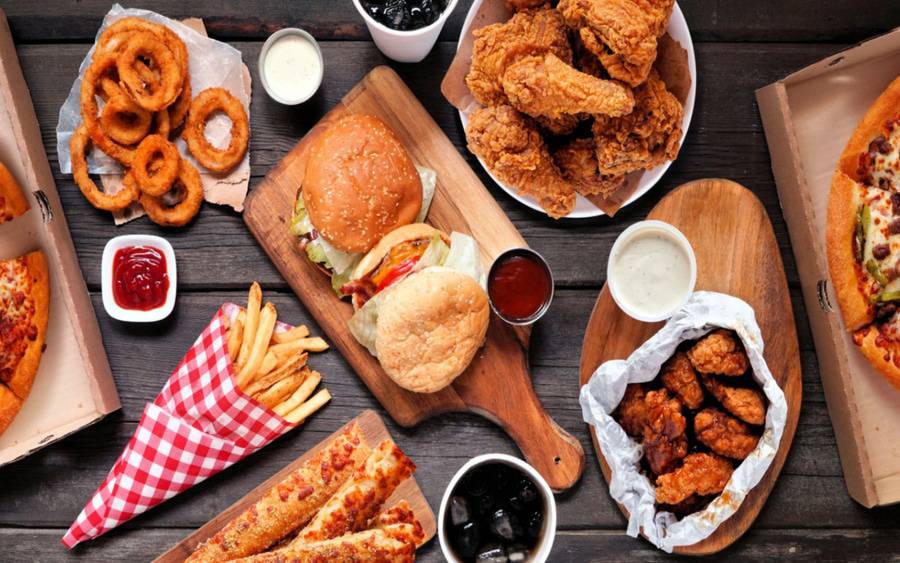 Foods that are not healthy for heart patients, including fried chicken, French fries, hamburgers, pizza, onion rings.