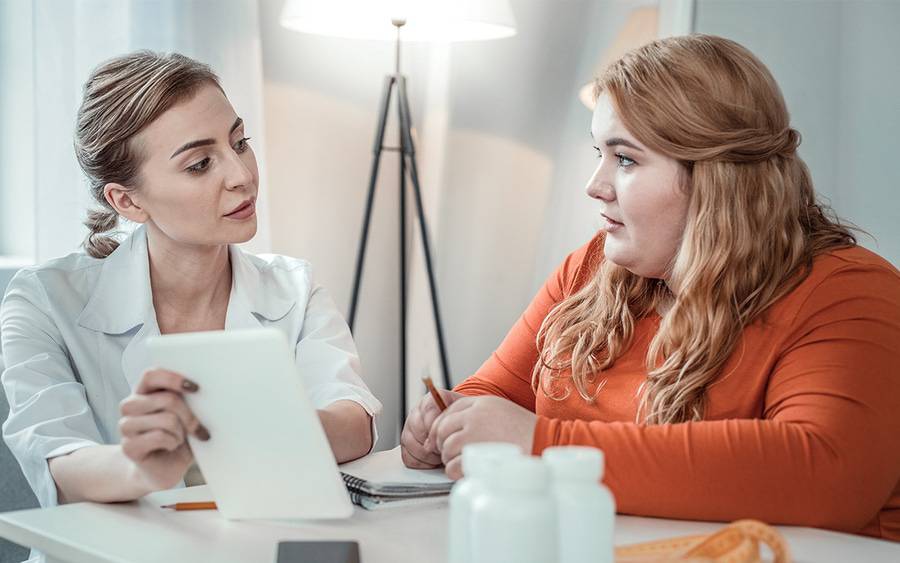 A bariatric surgery doctor discusses gastric sleeve surgery with a patient.