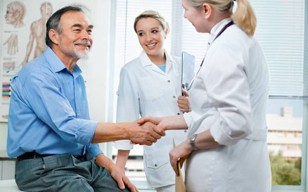 Two doctors visit with a male patient showing how Scripps and Cigna formed an alliance to deliver innovative healthcare. 