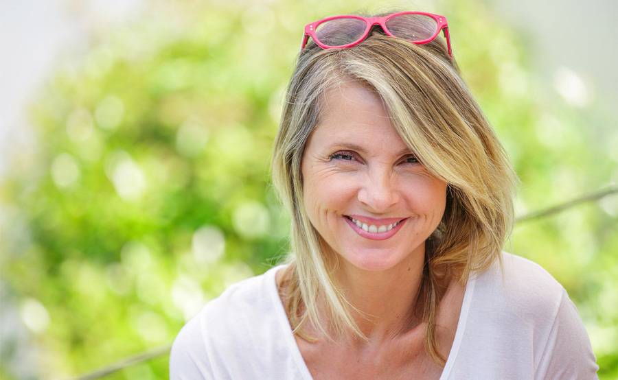 A younger woman smiling outdoors