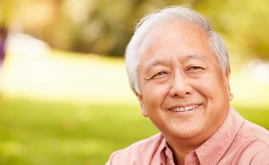 A older male enjoying a day outside near a park illustrating what life can be like after treatment for gi.