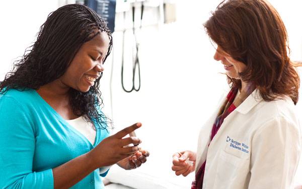 A woman with diabetes checks her blood sugar in front of her endocrinologist.