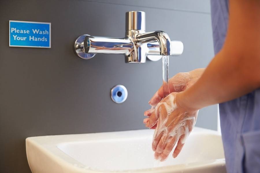 A doctor washes her hands at a hospital sink as part of a strategy to fight a Hepatitis A outbreak.