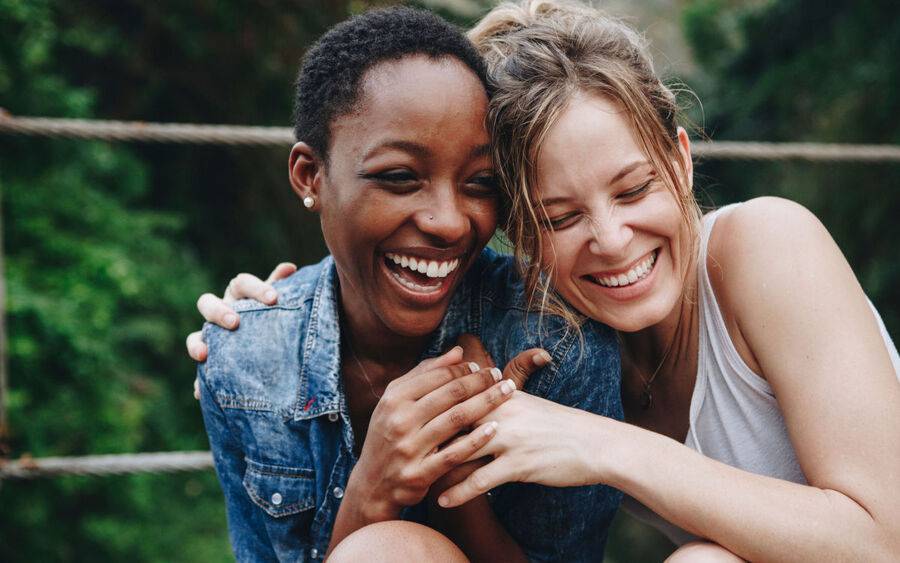 Two women experience happiness by laughing together.