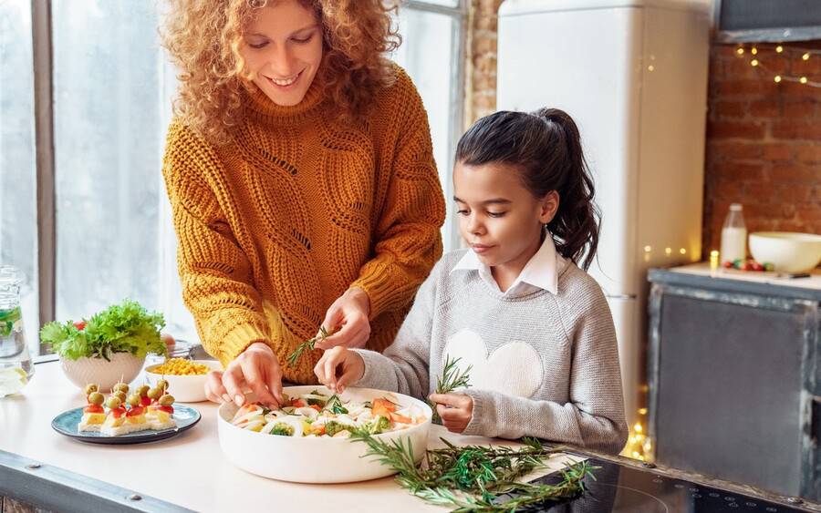 A mother and daughter in the kitchen preparing a healthy holiday meal.