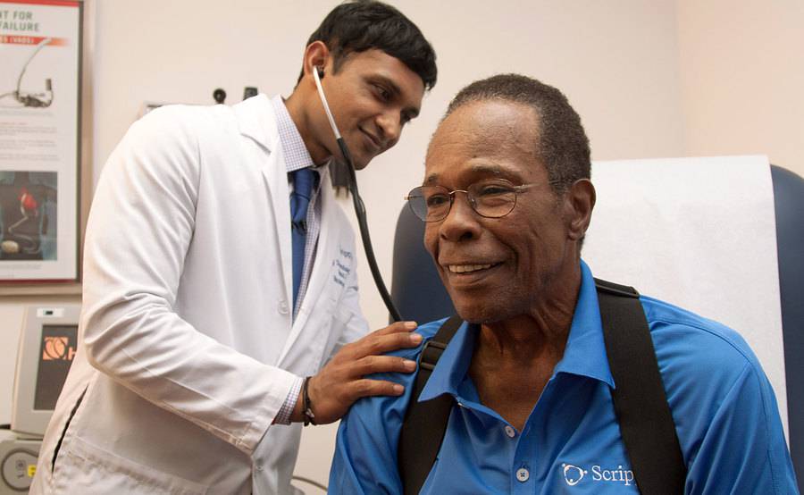 Scripps Clinic cardiologist Ajay Srivastava, MD, uses a stethoscope during a heart examination with Hall of Famer Rod Carew.