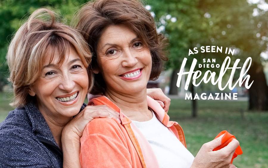 Two middle-aged women smile while enjoying some time outdoors. SD Health Magazine