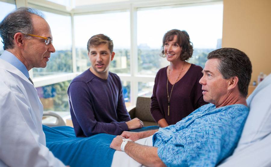 Cardiologist Martin Charlat, MD, discusses heart care with a patient and his family members.