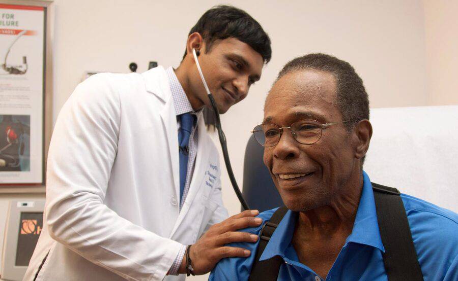 Scripps Clinic cardiologist  Ajay Srivastava, MD, uses a stethoscope during a heart examination with Hall of Famer Rod Carew.