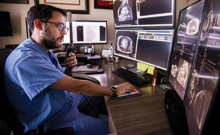 Jorge Gonzalez, MD, reviews images of a heart at his desk, representing heart treatment and diagnosis at Scripps Health. 