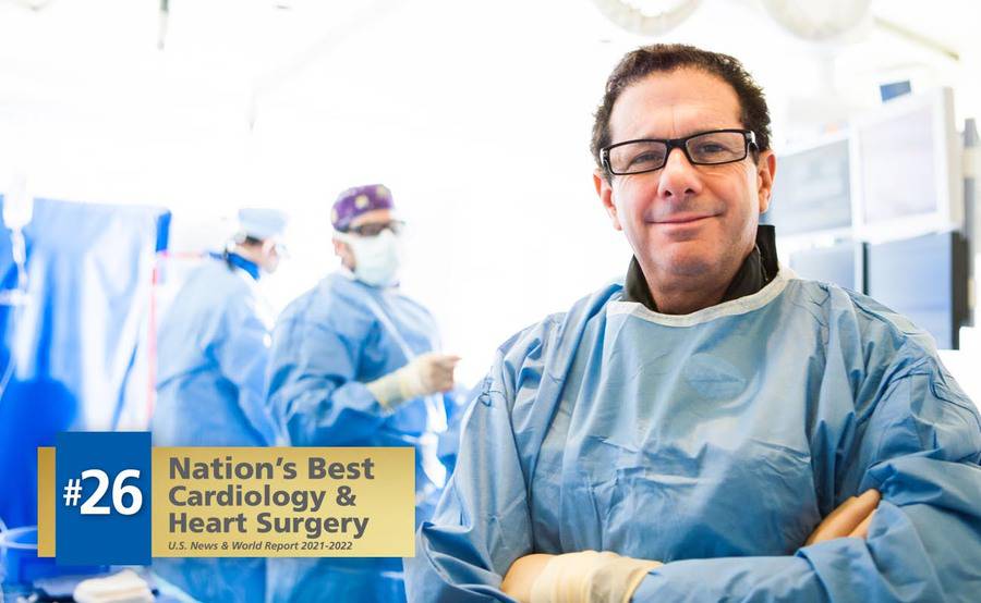 A cardiologist in a surgery gown with other cardiologists as part of the interventional cardiology program at Scripps. 