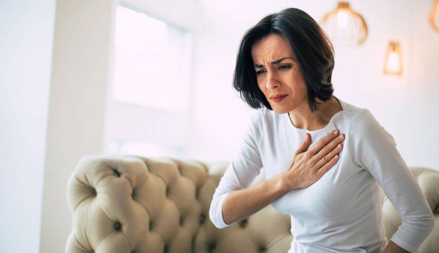 A woman grabs her chest, wondering if she has indigestion or a heart attack.