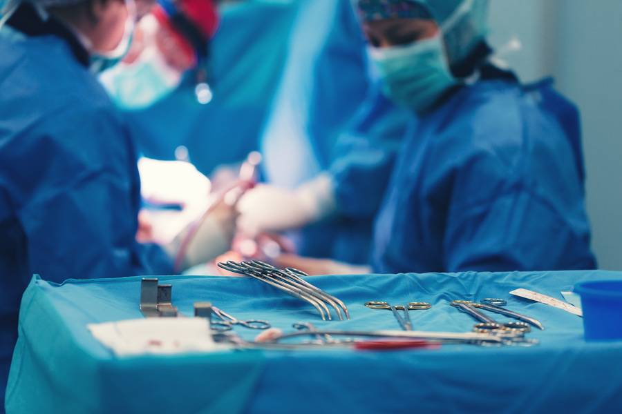 A surgical team works on a heart patient in the operating room.