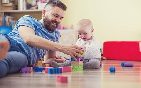 Dad and baby playing on the floor