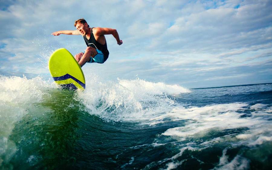 A surf athlete rides a wave to the San Diego shoreline.