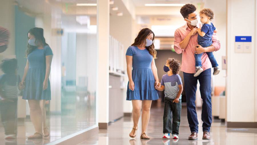 Two adults and two young children walk down the hallway at Scripps Health. 