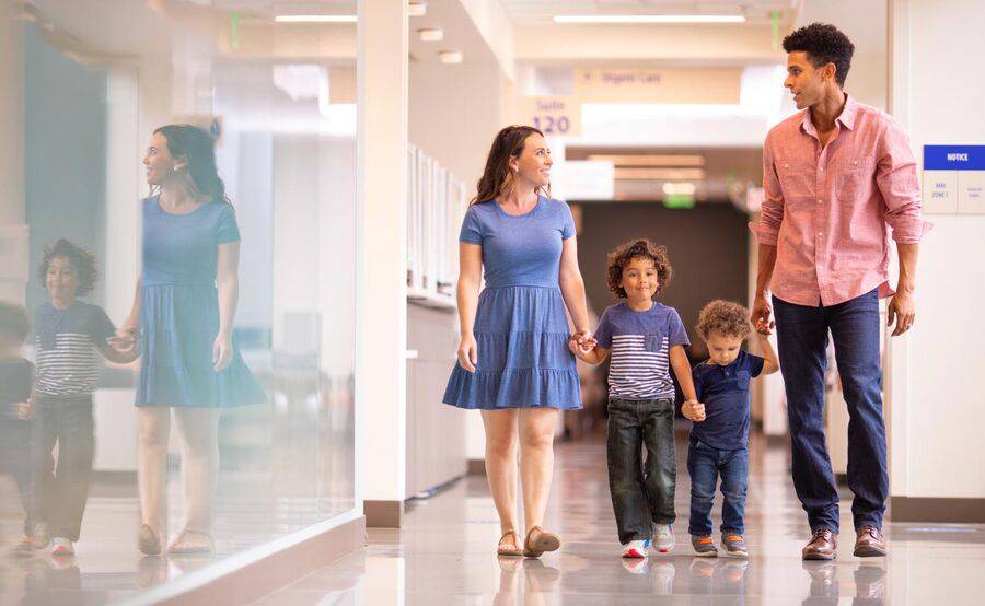 A young, multi-ethnic family walks a hallway at a Scripps hospital, representing one of 30 locations throughout San Diego.