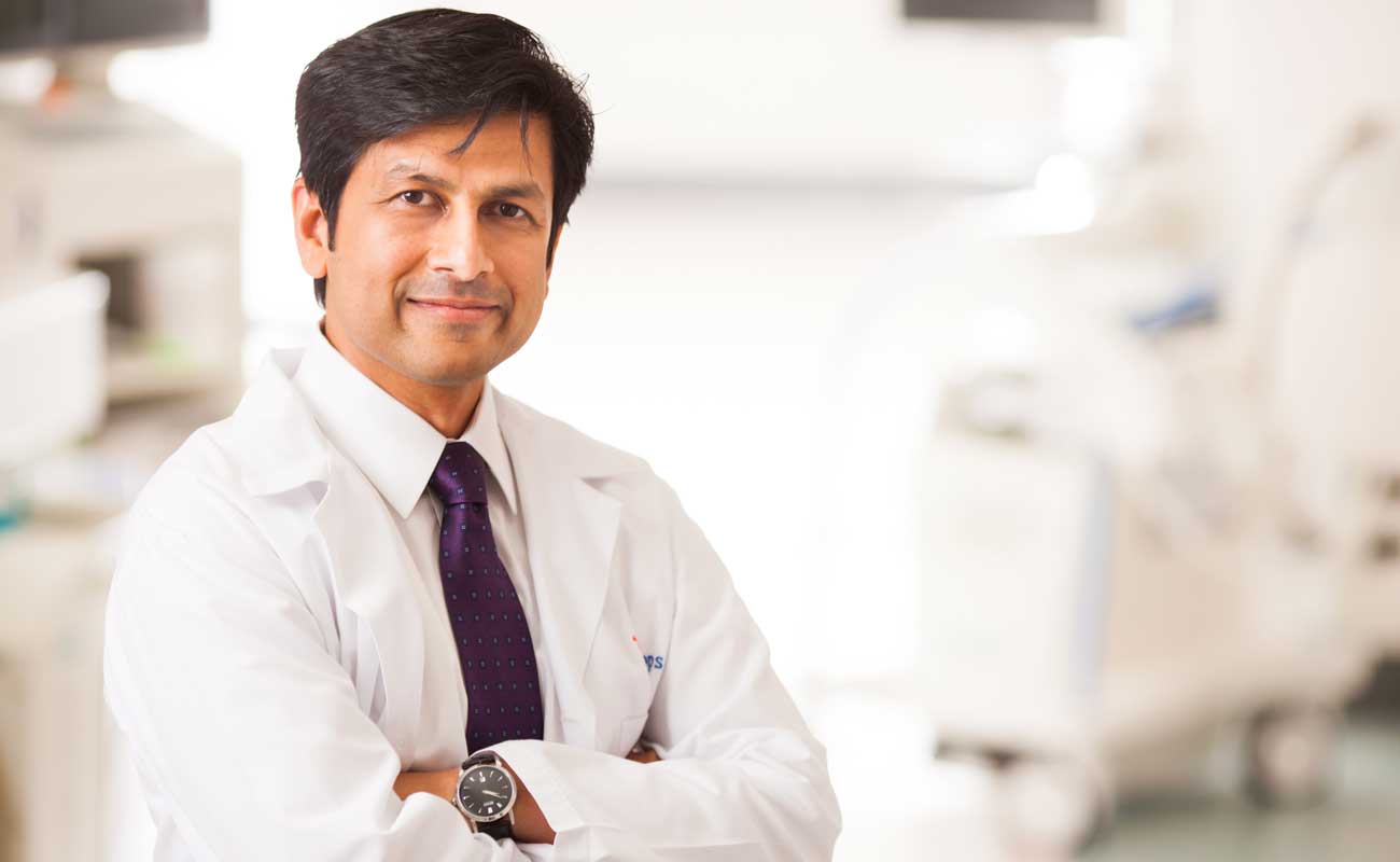 Scripps arrhythmia specialist standing in front of equipment used to treat this heart condition.