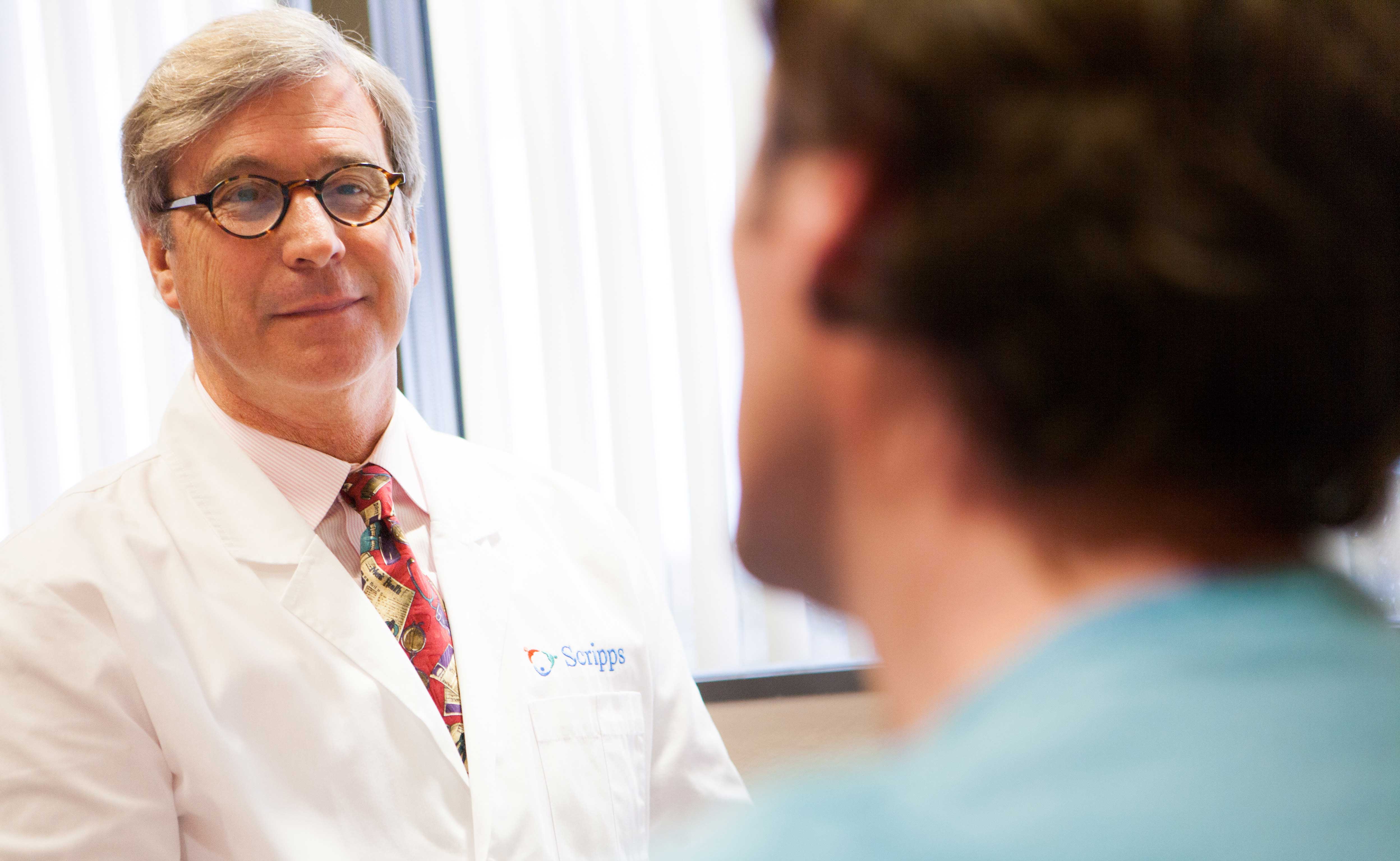 A Scripps physician talks with a patient, representing common questions about Scripps Center for Executive Health.