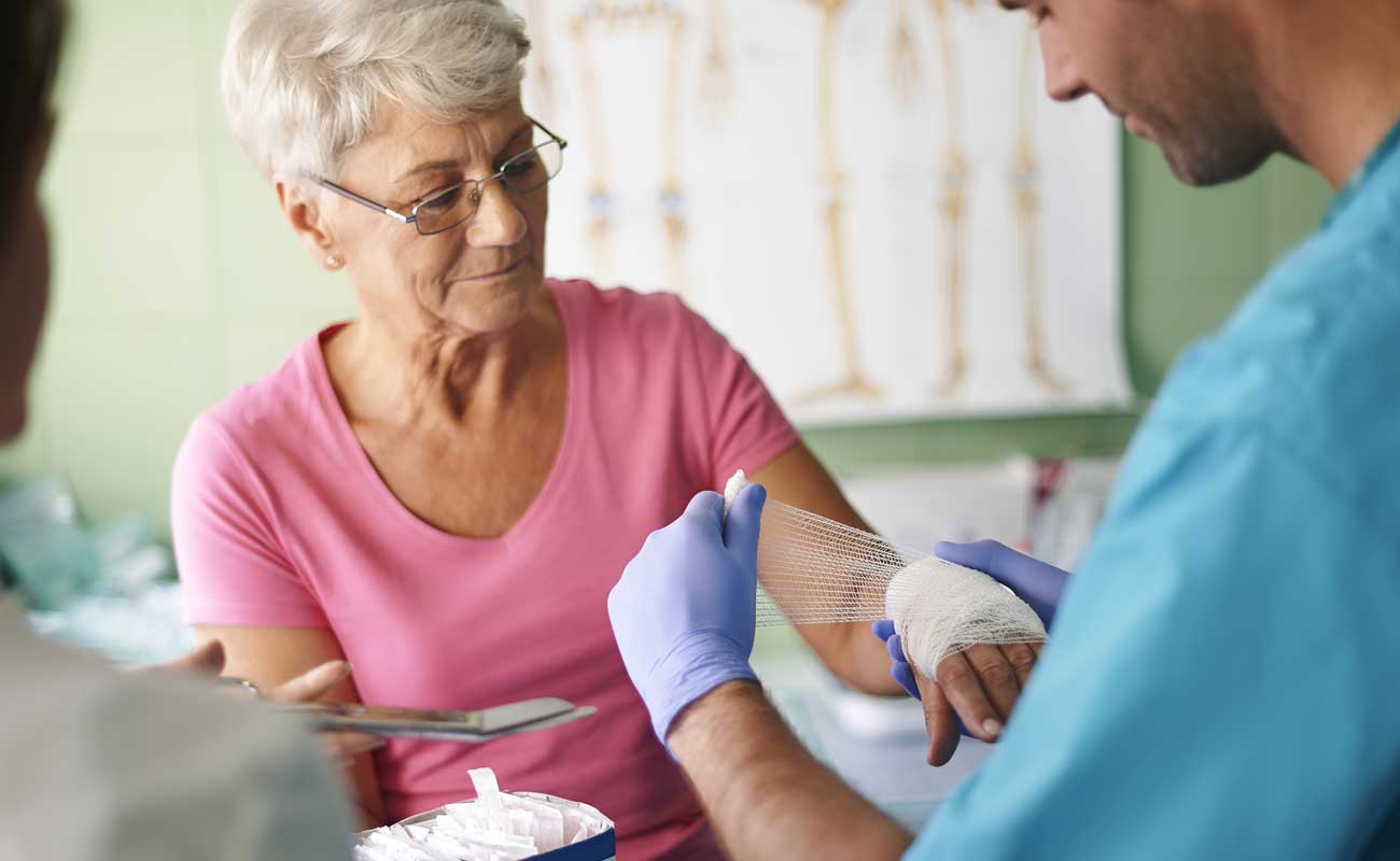 Scripps wound therapy specialist provides treatment to an elderly woman with a hand injury.
