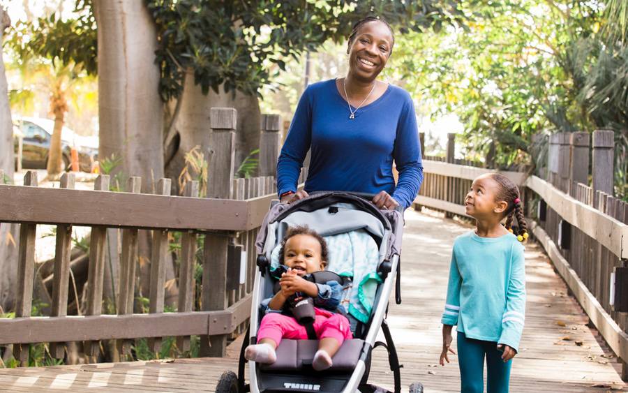 Toluwalse Ajayi, MD, 
 walks with her two daughters, one in a stroller, as she balances her job as a palliative care physician, mother and president of the San Diego County Medical Society.