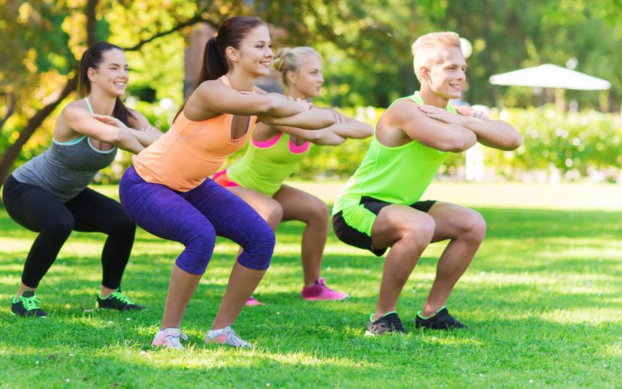 A fit and attractive group of young people exercise in a park as one of six ways to reduce inflammation.