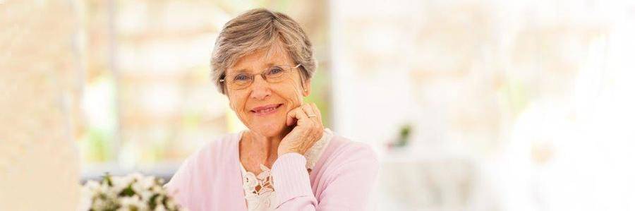 A relaxed elderly woman enjoys a peaceful moment in a pleasant indoor setting.