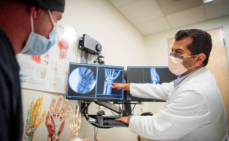 Kalpit Shah, MD, Orthopedic Surgeon at Scripps Clinic reviewing a wrist X-ray with a patient.