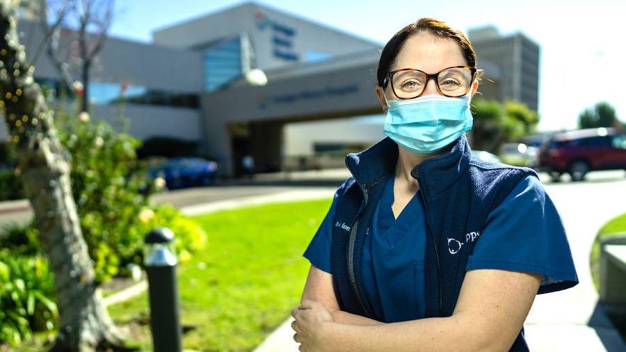Keri Cipperoni, RN is standing outside with a face mask and a Scripps blue vest, one of the eight Scripps Nurses of the Year 2020.