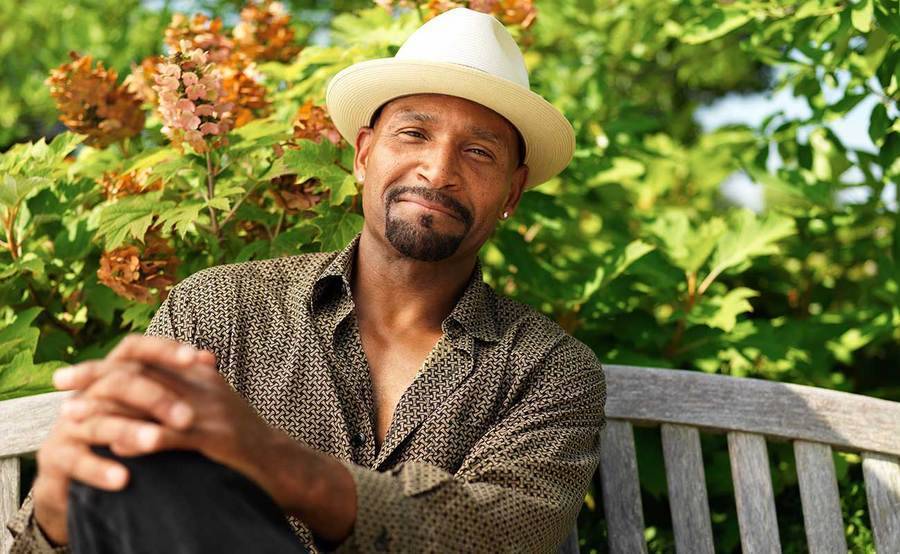 A smiling middle-aged African-American man on a park bench represents the full life that can be led after kidney cancer treatment.