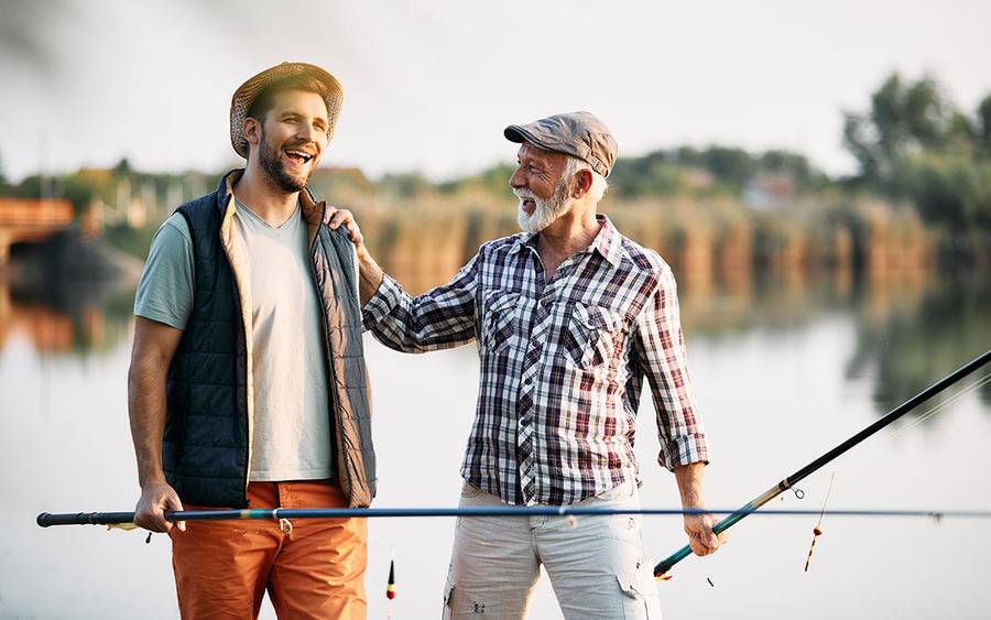Two men outside fishing and laughing
