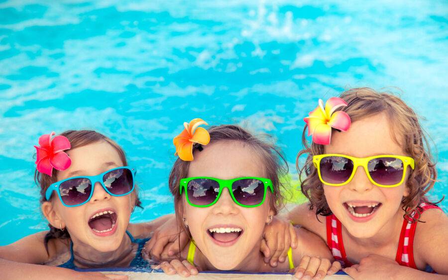 Kids on spring break when travel picks up playing in pool at hotel.