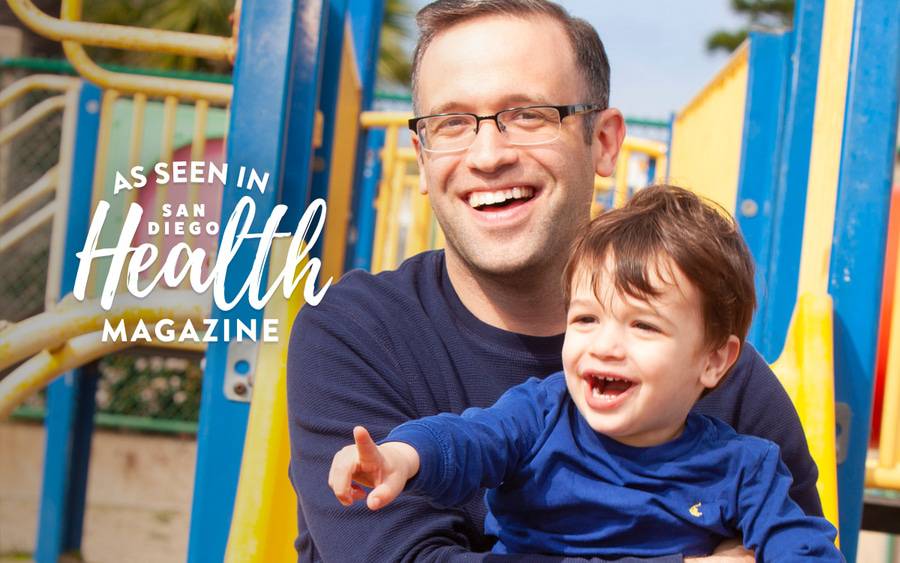 Leonard Sokol, MD, sits at the playground with his son. San Diego Health Magazine
