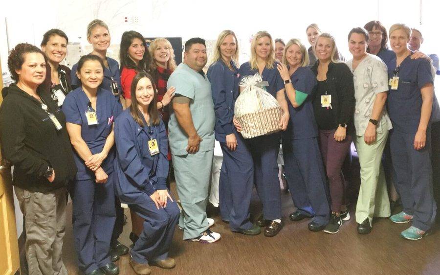 Lora Seelicke, who's holding a gift basket, stands with the Scripps La Jolla delivery staff after she won a nursing award.