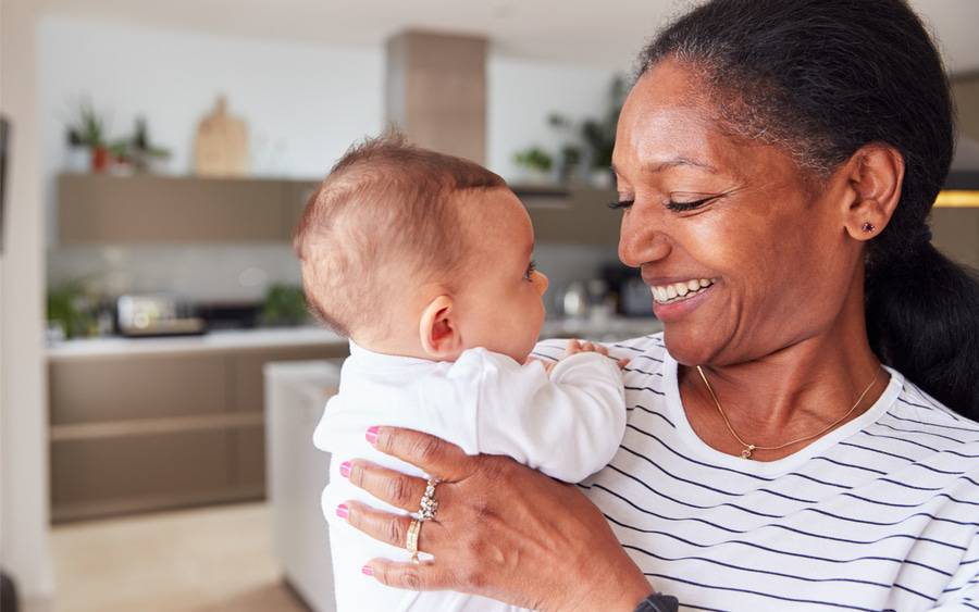 A loving grandmother holds a 3-month-old baby.